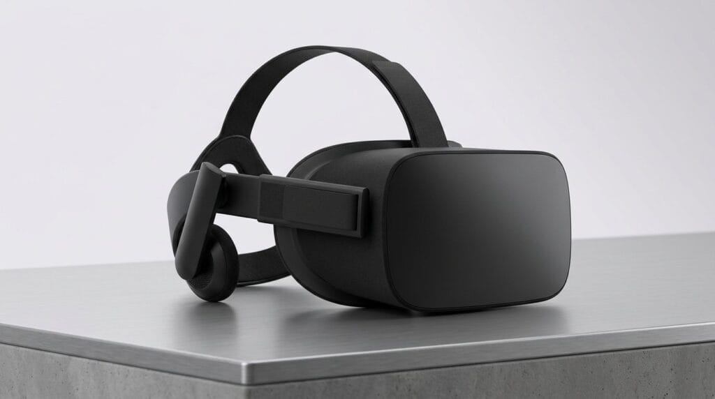 Black virtual reality headset on a gray table against a white background, with soft directional light.